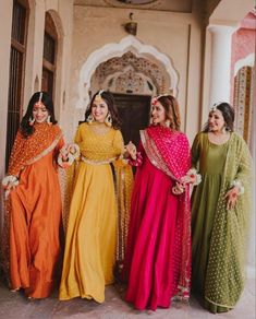 three women in colorful dresses standing next to each other