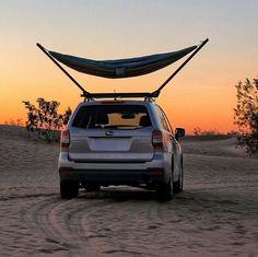 the back end of a car with a surfboard strapped to it's roof