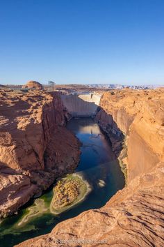 a large body of water in the middle of a desert area with rocks and cliffs