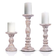 three white candles sitting next to each other