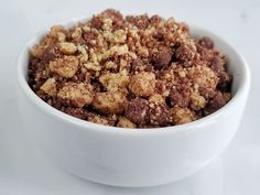 a white bowl filled with crumbs on top of a table