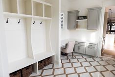 a white and brown tiled floor in a room with some shelves on the wall next to it