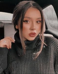 a woman sitting in the back seat of a car with her hand on her shoulder