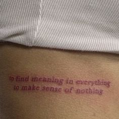 a person with a tattoo that reads to find meaning in everything to make sense of nothing