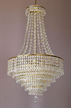 a chandelier hanging from the ceiling with lots of crystal beads on it's sides