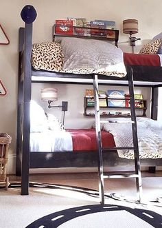 two bunk beds with ladders in a bedroom next to a lamp and bookshelf