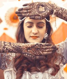 a woman with her hands covered in henna