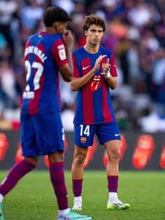 two soccer players standing next to each other on a field