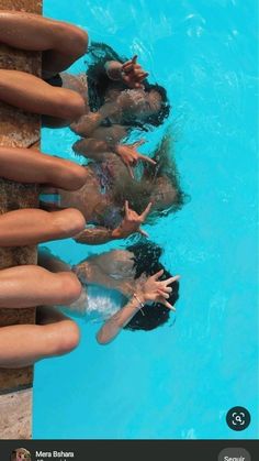 three people are swimming in a pool with their hands on the side of the pool