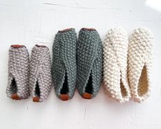 four knitted mittens lined up on top of each other in different colors and sizes