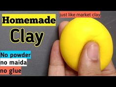 a hand holding a yellow clay ball with the words homemade clay written in red on it