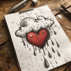 a drawing of a heart with rain and drops on the paper next to it is a pen