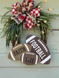 a wreath with footballs and plaid bow hanging on the wall next to a door