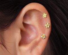 a woman's ear with three small flowers on it