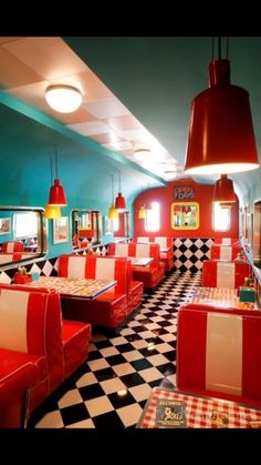 the interior of a diner with checkered flooring and red booths, black and white checkerboard