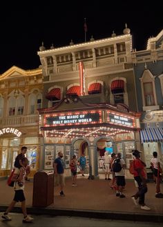 people are walking around in front of a theater