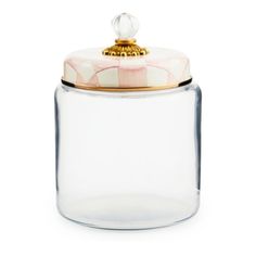 a glass jar with a gold lid and checkered pattern on the top, sitting on a white surface