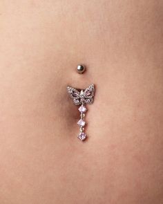 a woman's belly is adorned with a butterfly and pearl brooch pin on her stomach