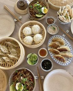 a table topped with lots of different types of food and bowls filled with soups