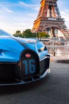 the front end of a blue bugatti car with the eiffel tower in the background