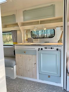 a kitchen area with cabinets, stove and sink in a recreational vehicle or camper