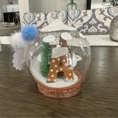 a snow globe with an ornament in the shape of a house and a deer