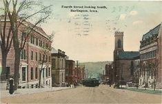 an old postcard shows the street in front of some buildings