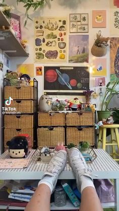 a person's feet resting on a table with baskets and plants