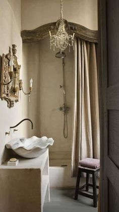 a bathroom with a chandelier, sink and shower in the middle of it