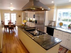 a kitchen with a stove top oven sitting next to a dining room table