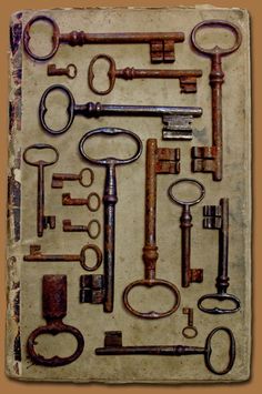 an assortment of old keys are displayed on a piece of parchment paper that has been altered