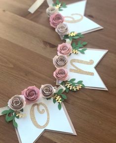 some paper flowers are laying on top of each other and the number twenty five is decorated with gold foil