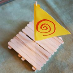 a small yellow flag sitting on top of a wooden stick