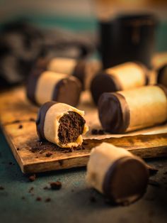 chocolate covered desserts sitting on top of a wooden cutting board