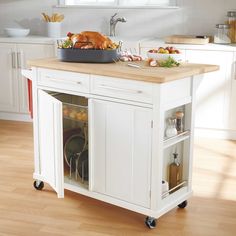 a kitchen island with a turkey on it in the middle of a wood floored room