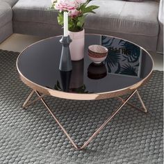 a living room with a couch, coffee table and vases on the carpeted floor