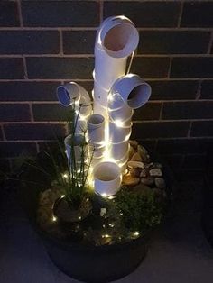 a planter filled with lots of white cups and lights