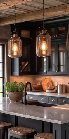 a kitchen with two lights hanging from the ceiling and some stools in front of it