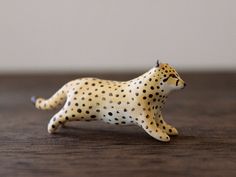 a toy cheetah running on a wooden table