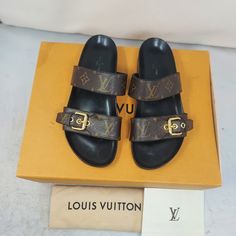 Louis Vuitton Brown Buckle Bom Dia Monogram Flat Sandal Size Eu 37 Us 7 Womens Comes With Dustbag And Box 100% Authentic *Price Is Firm* Color: Cacao Brown Classic Dark Brown Slip On Sandal With Allover Lv Monogram Print Patent Monogram Canvas Decorative Buckle - 2 Straps Across (Not Adjustable) Anatomic Insole Louis Vuitton-Engraved Buckle Smooth Outsole Please Note Signs Of Wear On Bottom As Shown. Please Note Scratches/Scuffs Have Been Polished Over As Shown. Text Faded On Footbed As Shown Louis Vuitton Brown, Lv Monogram, Monogram Prints, Louis Vuitton Shoes, Monogram Canvas, Flat Sandals, Slip On Sandal, Women's Shoes Sandals, Dark Brown