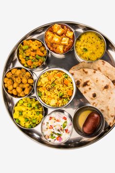 a silver plate with different types of food on it, including pita bread and vegetables