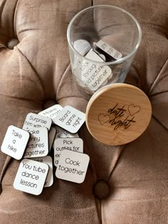 a glass filled with lots of magnets sitting on top of a brown leather couch