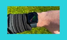 an apple watch on someone's wrist with the screen showing green grass in the background