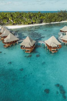 an aerial view of some huts in the water