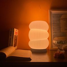 a lamp sitting on top of a table next to an open book