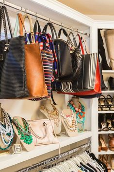 many purses and handbags are hanging on the wall in this closet with white shelving