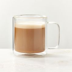 a glass mug filled with liquid sitting on top of a table