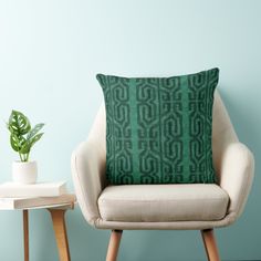 a chair with a pillow on it next to a potted plant and a table