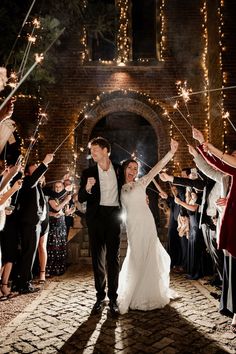 a newly married couple walking down the aisle with sparklers in their hands