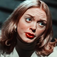 a woman's face with red lipstick and long blonde hair is shown in this artistic photo